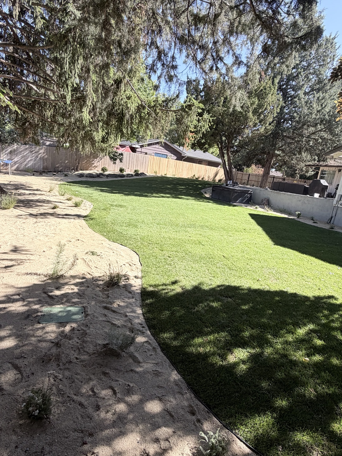 Revitalized Boise area back yard with green lawn and planting beds