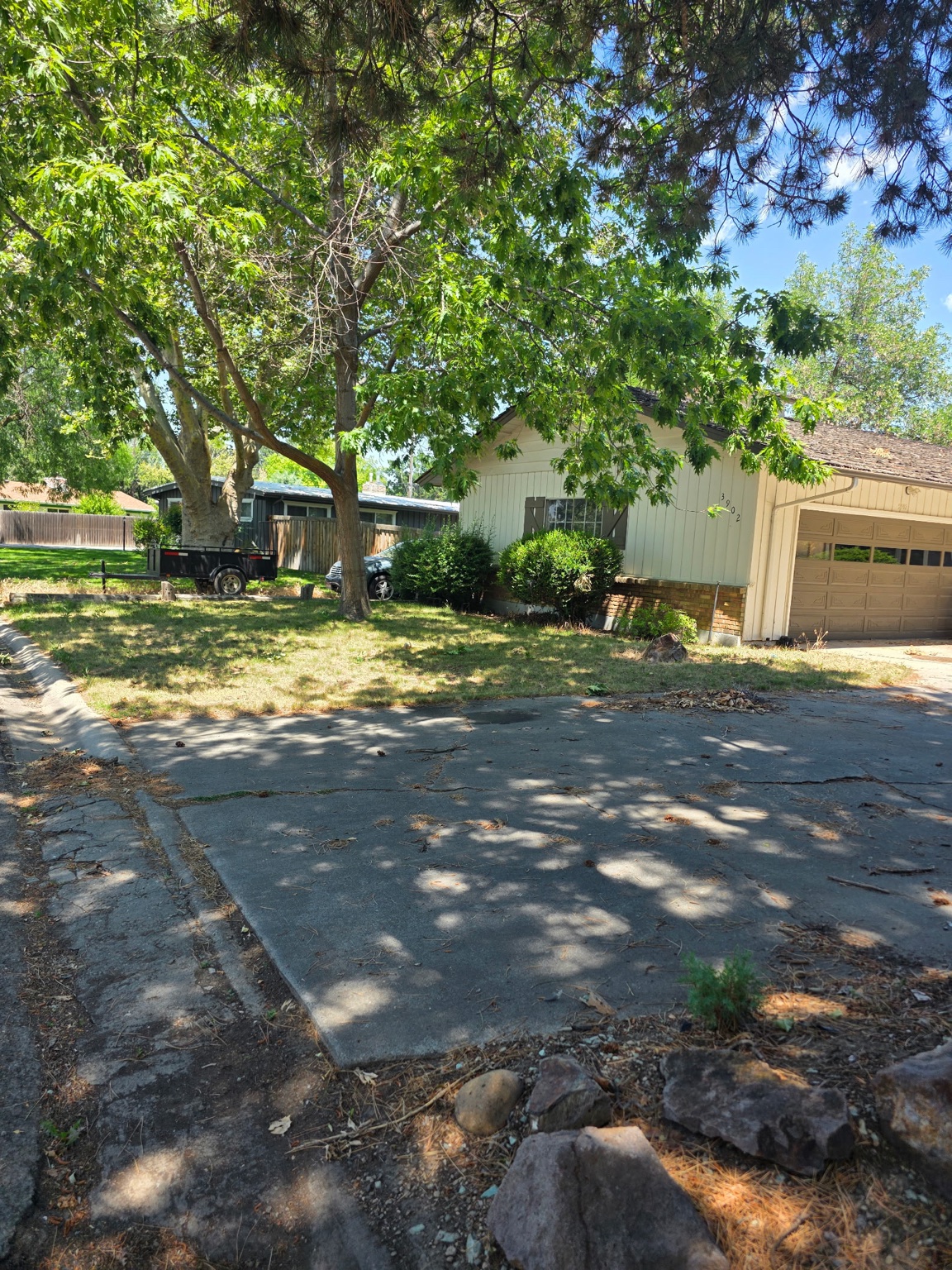 Front yard with sparse grass and an older paved area before revitalization