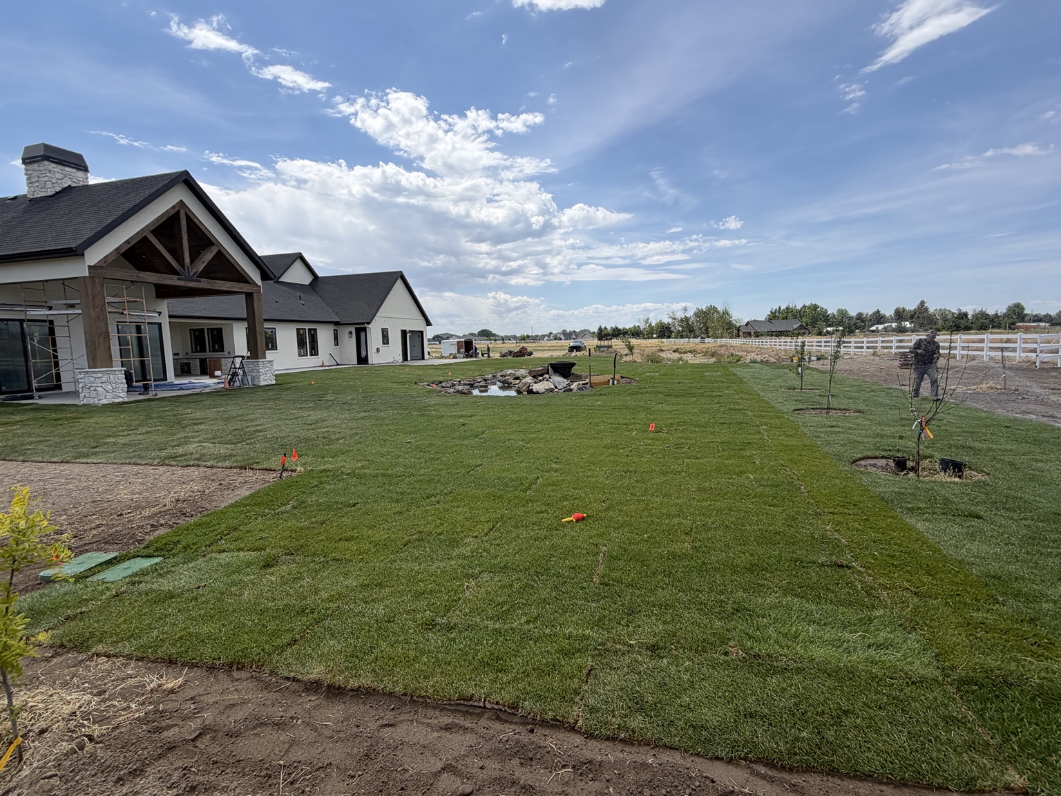Middleton back yard with fresh sod, newly planted trees, and a rock-lined water feature